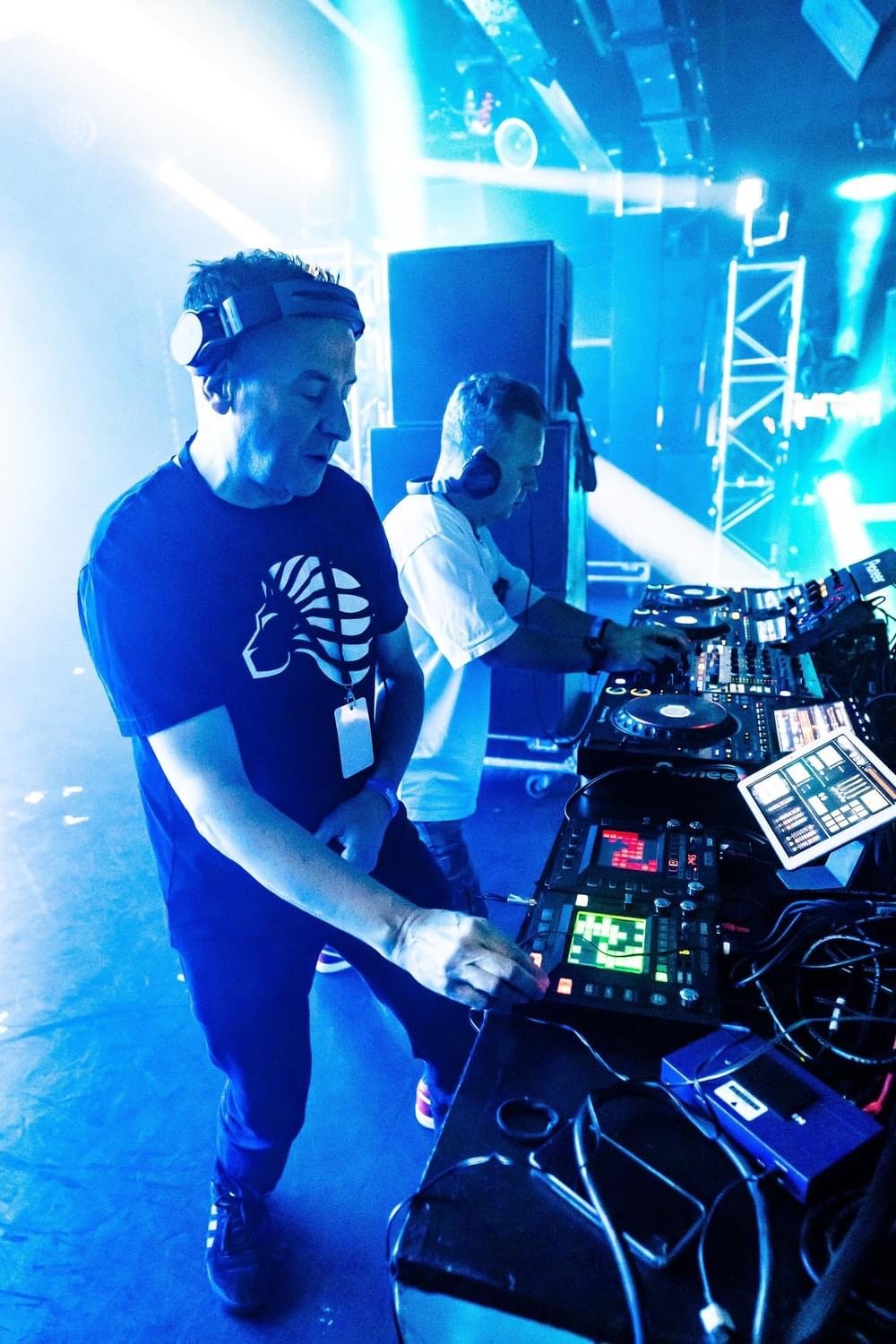 Utah Saints performing at their decks under blue club lights