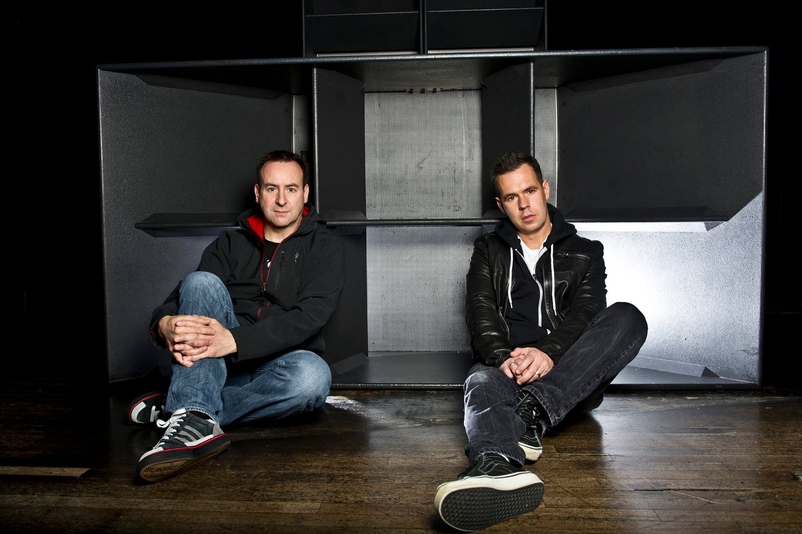 Utah Saints duo posing in front of a large speaker system